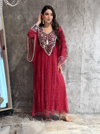 Woman wearing a maroon french lace embroidered dress lying on a textured surface