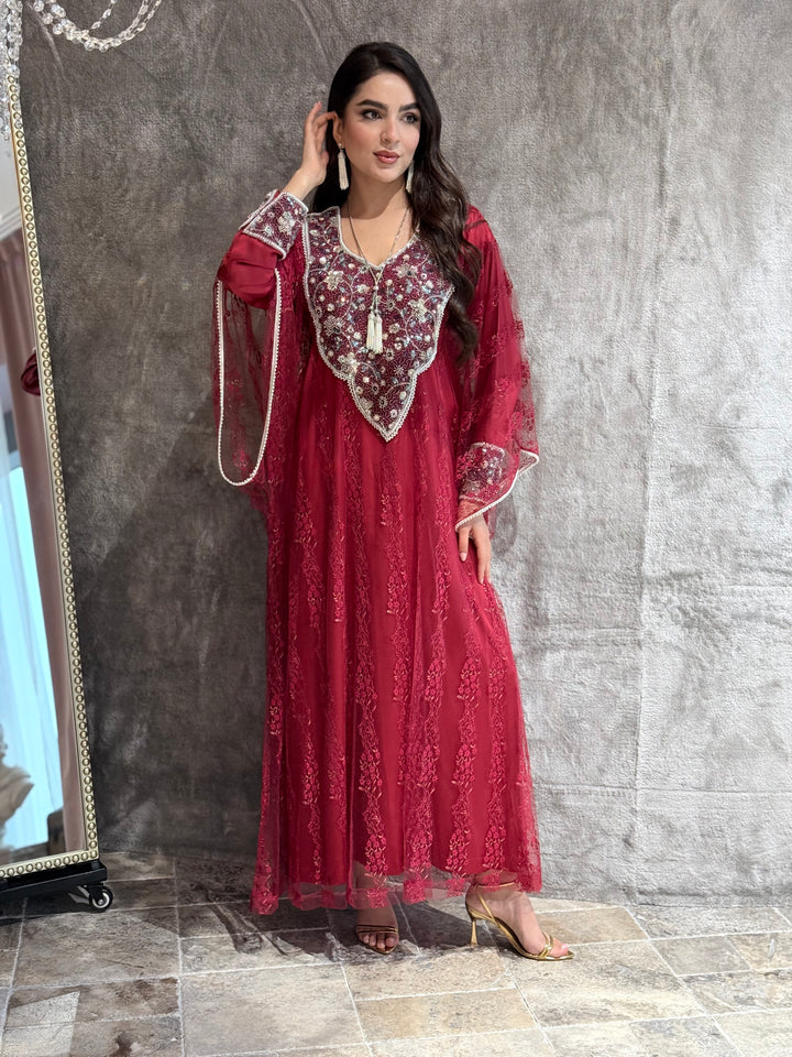 Woman wearing a maroon french lace embroidered dress lying on a textured surface