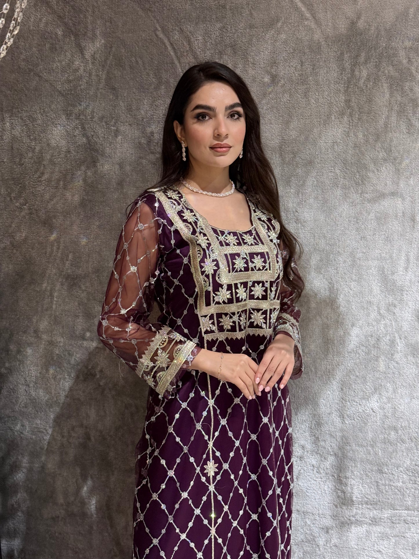 Woman in a luxury deep purple Embroidered Tulle kaftan Dress with Stone Detailing standing on a marble floor