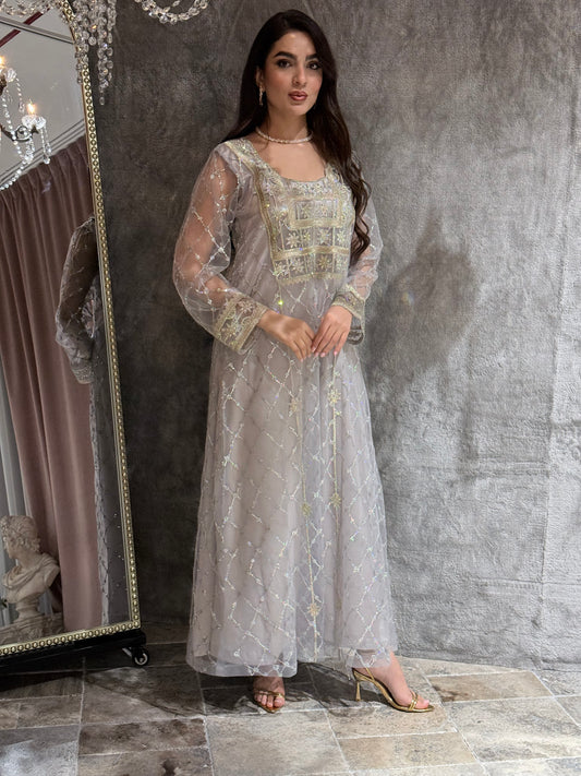 Woman in a luxury lighht grey Embroidered Tulle kaftan Dress with Stone Detailing standing on a marble floor
