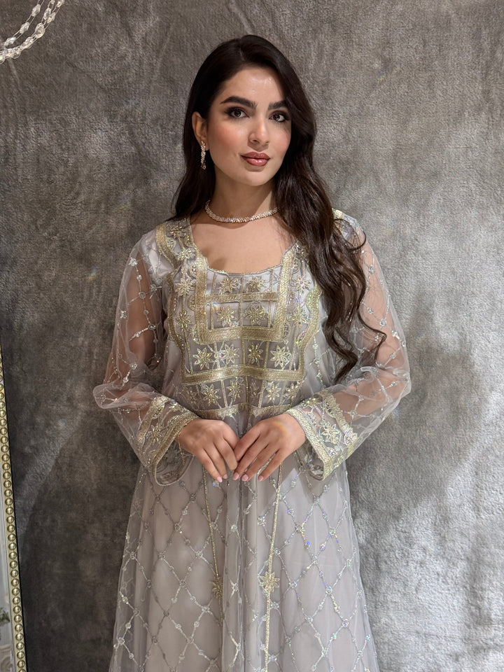 Woman in a luxury lighht grey Embroidered Tulle kaftan Dress with Stone Detailing standing on a marble floor