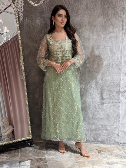 Woman in a luxury mint green Embroidered Tulle kaftan Dress with Stone Detailing standing on a marble floor
