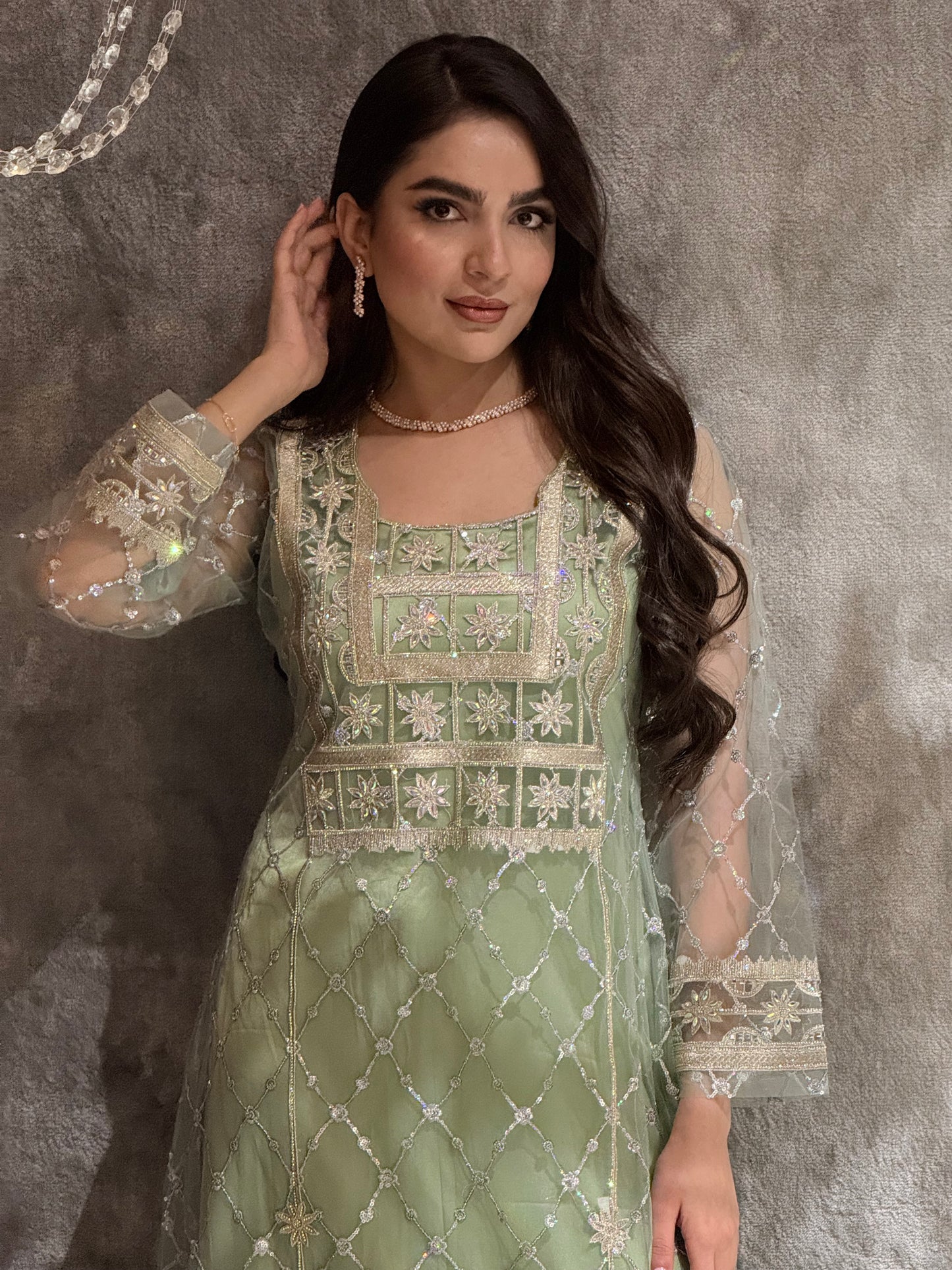 Woman in a luxury mint green Embroidered Tulle kaftan Dress with Stone Detailing standing on a marble floor