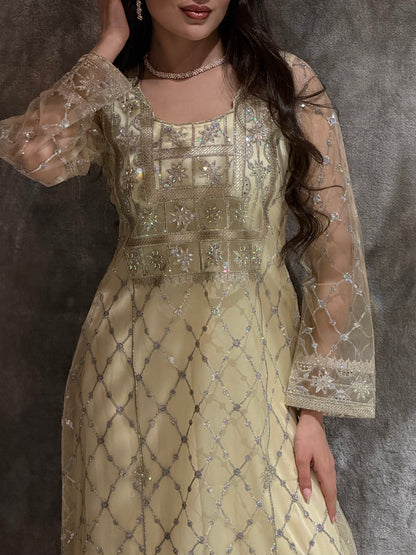 Woman in a luxury pale yellow Embroidered Tulle kaftan Dress with Stone Detailing standing on a marble floor