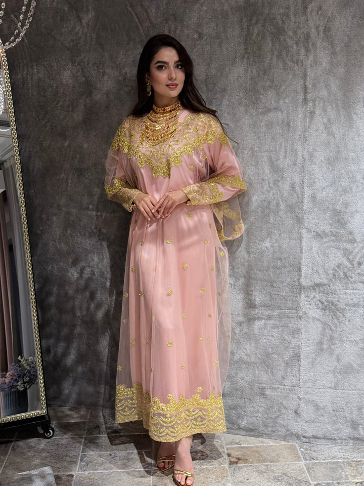 Woman in a Baby Pink Embroidered Tulle kaftan Dress standing on a gray tiled floor.