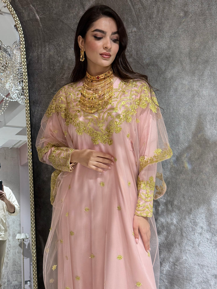 Woman in a Baby Pink Embroidered Tulle kaftan Dress standing on a gray tiled floor.