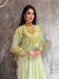 Woman wearing a Mint Green Embroidered Tulle jalabiya Dress with gold embroidery on a marble floor.
