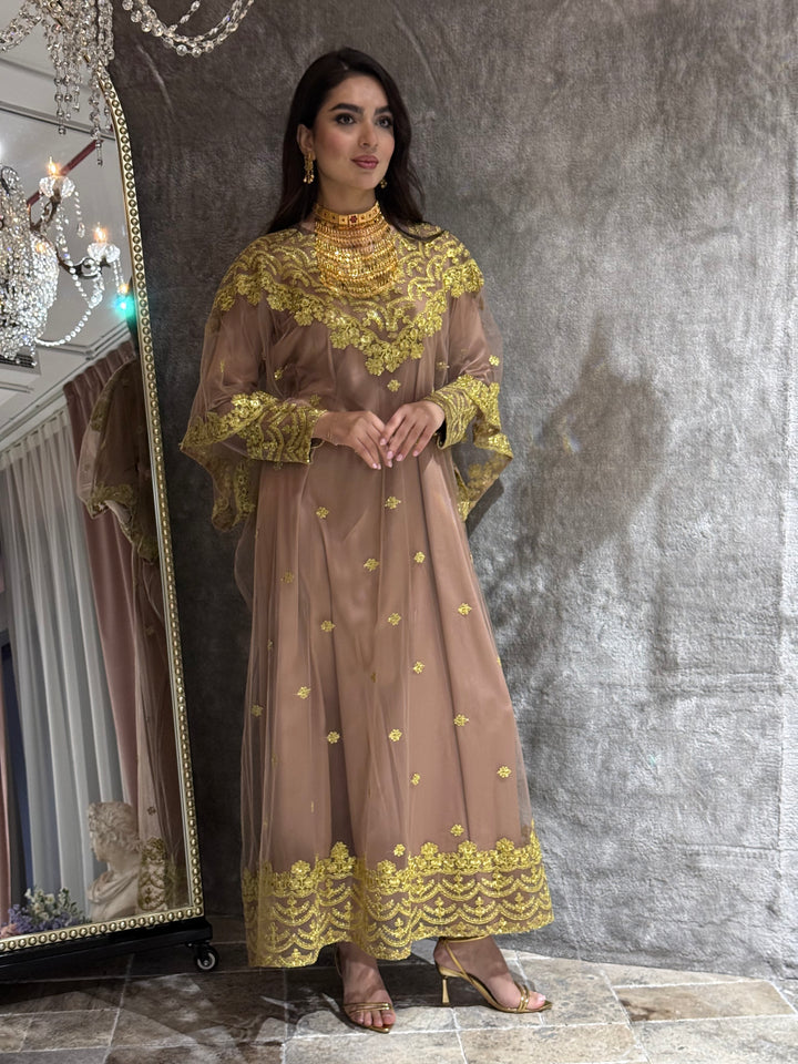 Woman in a coffee brown Embroidered Tulle kaftan dress standing in front of a mirror.