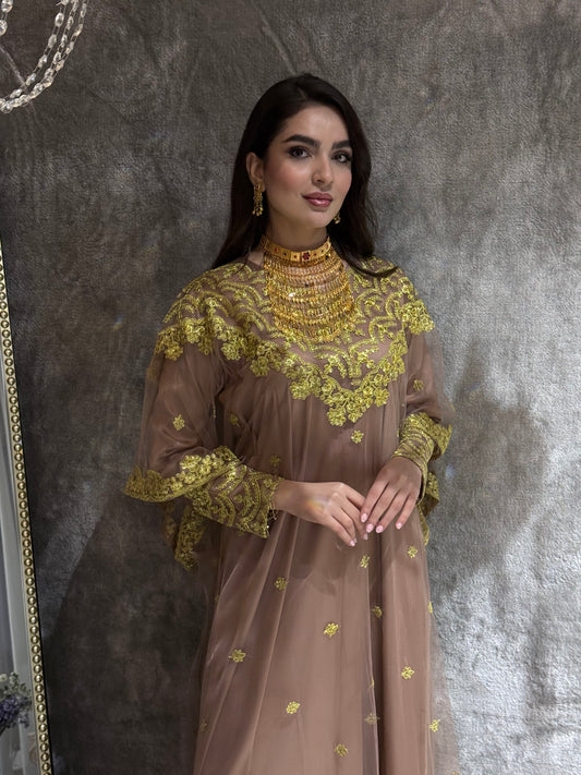 Woman in a coffee brown Embroidered Tulle kaftan dress standing in front of a mirror.