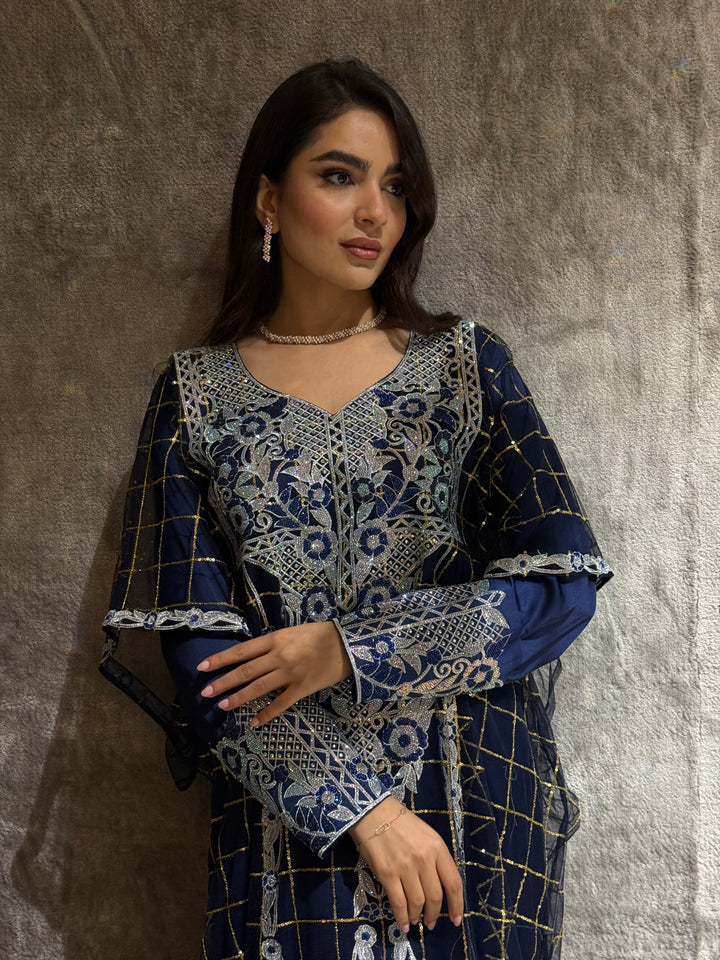 Woman wearing a Navy Blue Emirati Design Tulle kaftan Dress outfit on a textured floor.