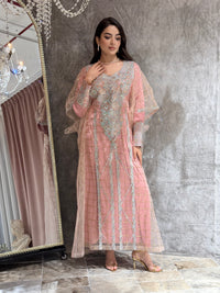 Woman in a Pink Emirati Design Tulle kaftan Dress outfit standing in front of a mirror.