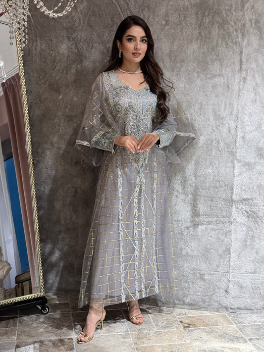 Woman in a long, Silver Grey Emirati Design Tulle jalabiya Dress standing in front of a mirror on a marble floor.