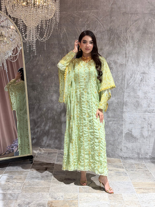 Woman wearing a Mint Green Luxury Embroidered Kaftan Dress in a room with gray tiles.