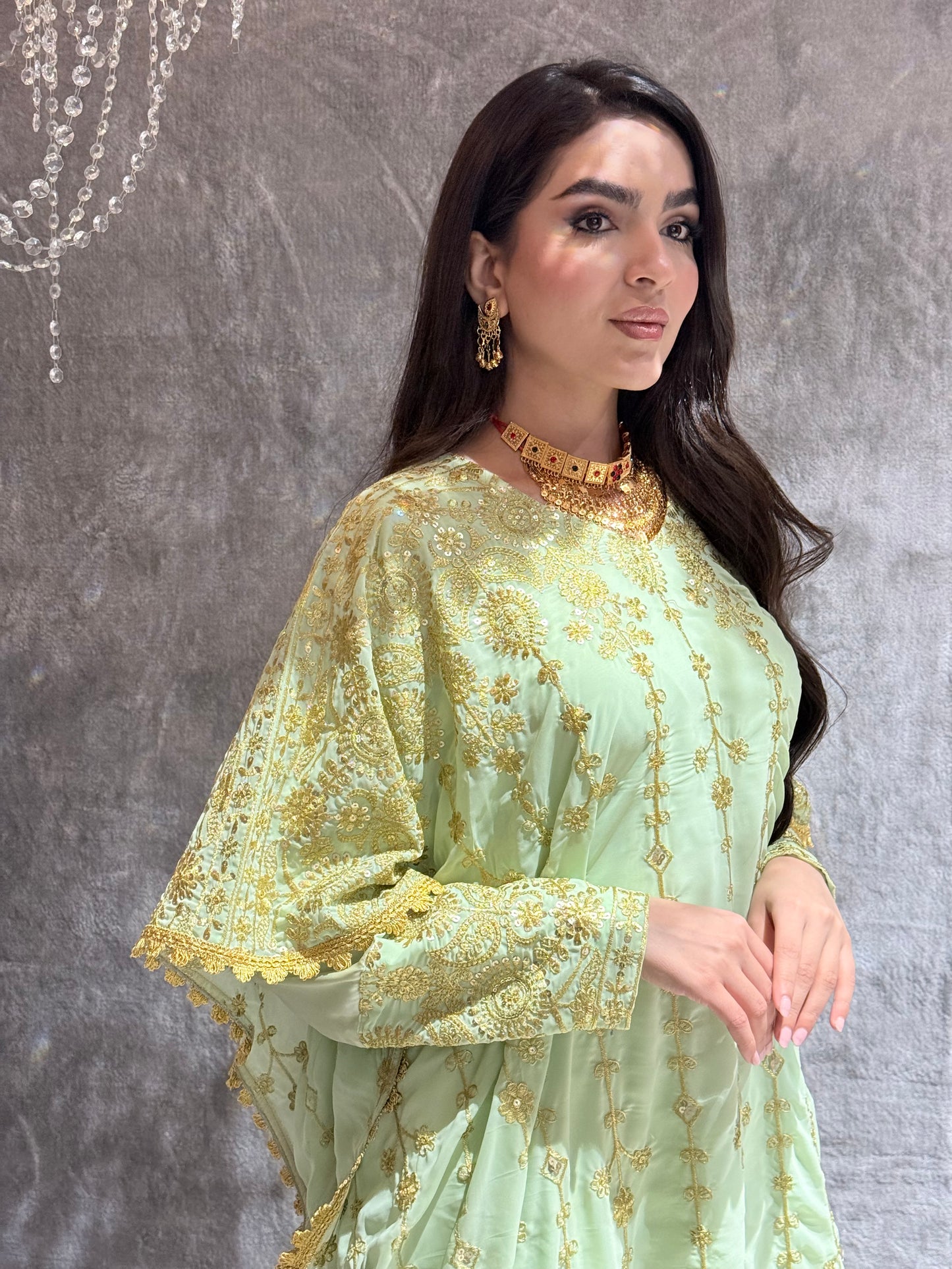 Woman wearing a Mint Green Luxury Embroidered Kaftan Dress in a room with gray tiles.