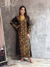 Woman in a black floral kaftan dress lying on a marble floor