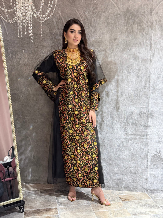 Woman in a black floral kaftan dress lying on a marble floor