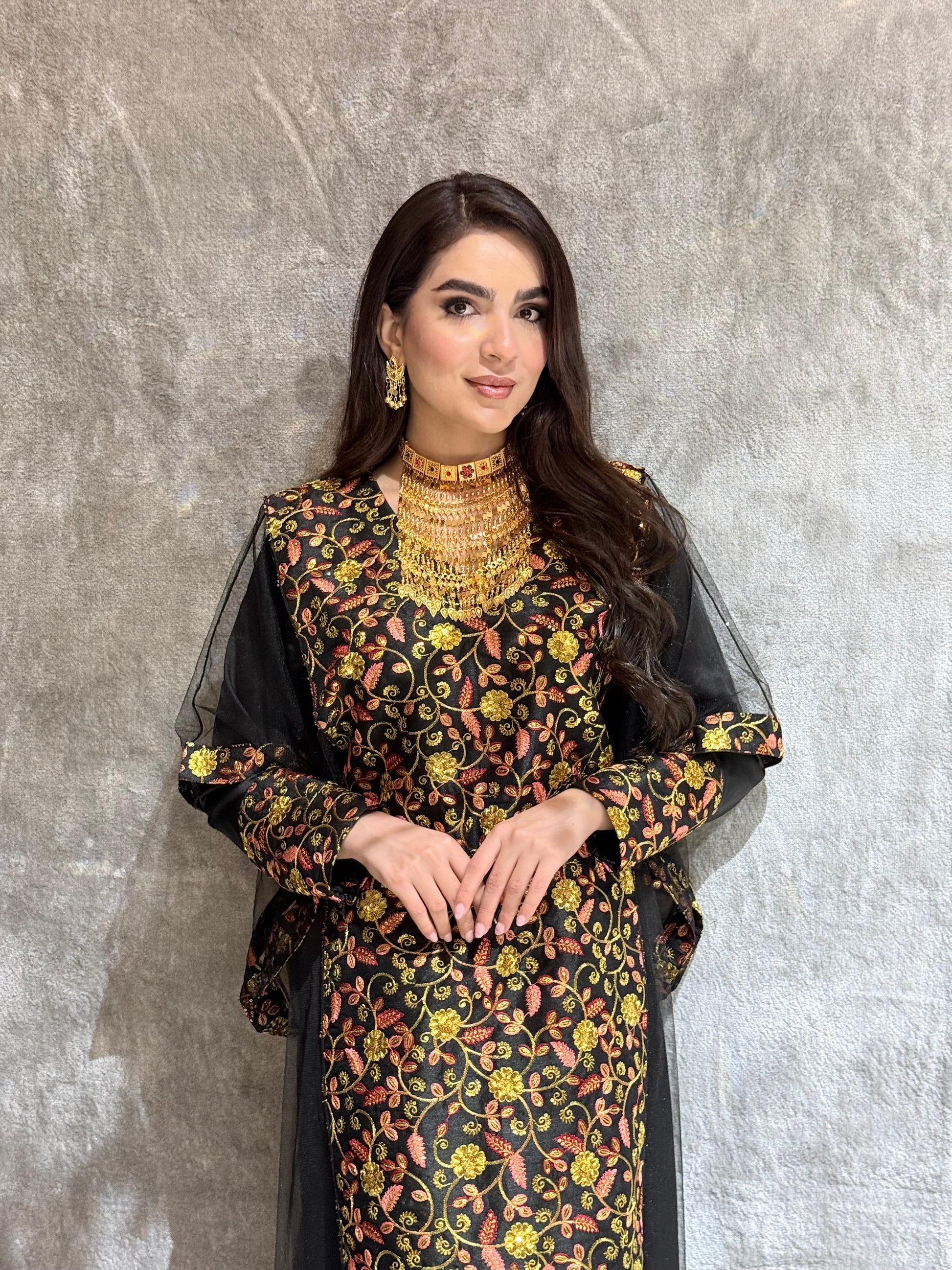 Woman in a  Black Floral Embroidered Kaftan lying on a textured surface