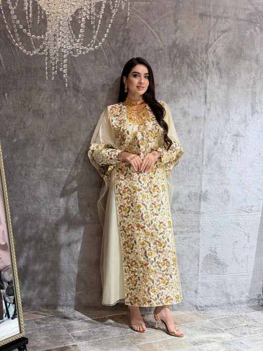Woman standing on a textured gray floor wearing a Cream Floral Embroidered Kaftan