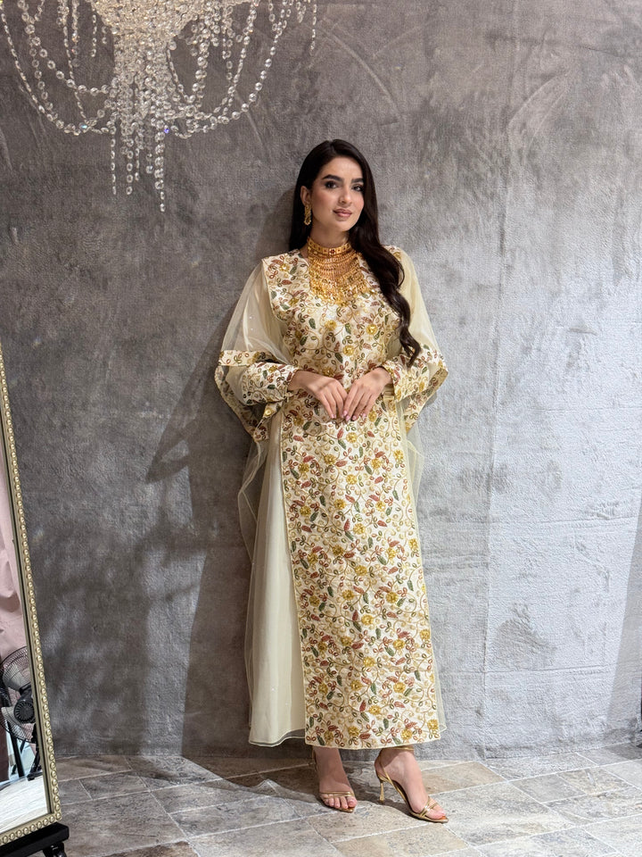 Woman standing on a textured gray floor wearing a Cream Floral Embroidered Kaftan