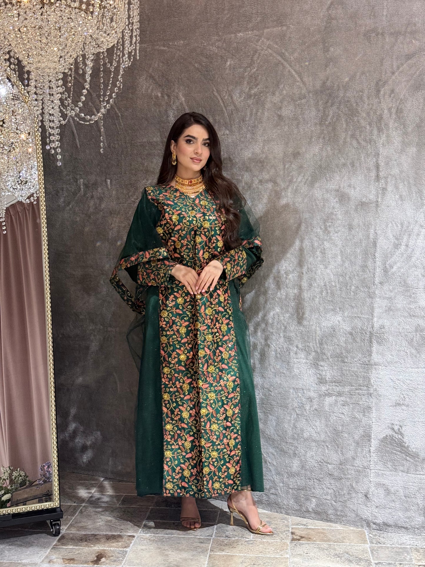 Woman in a Dark Green Floral Embroidered Kaftan standing on a gray floor.