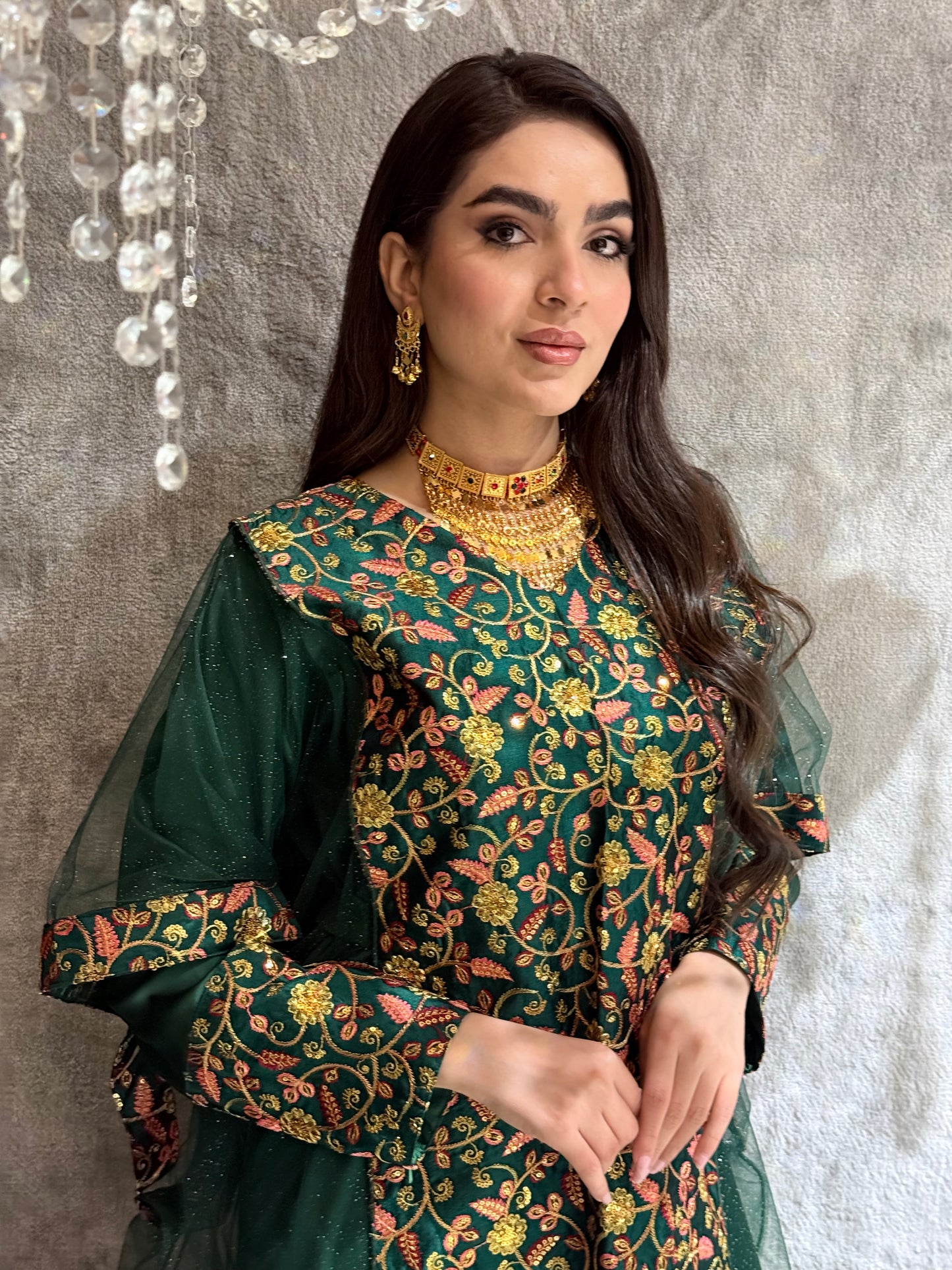 Woman in a Dark Green Floral Embroidered Kaftan standing on a gray floor.