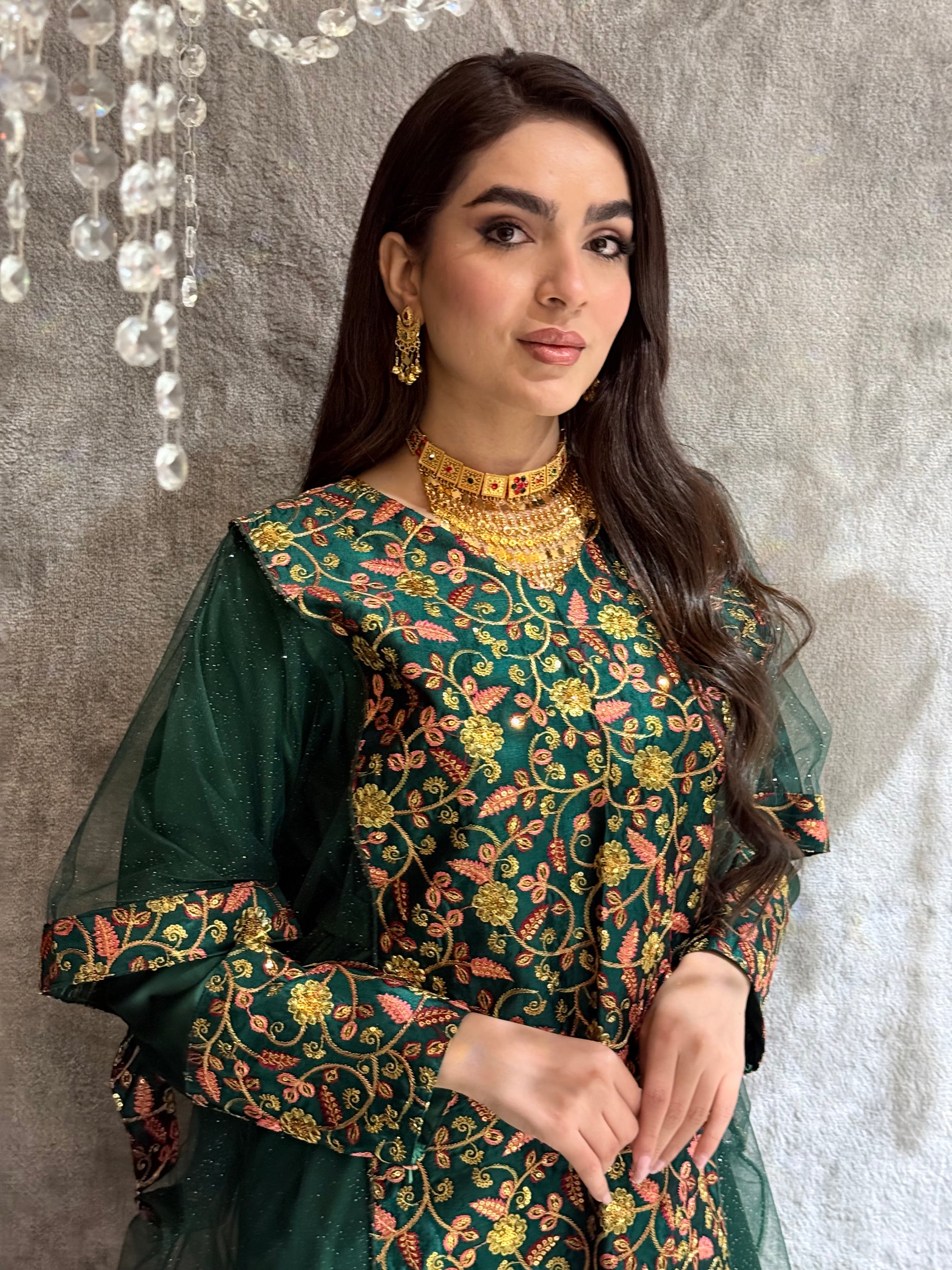 Woman in a Dark Green Floral Embroidered Kaftan standing on a gray floor.