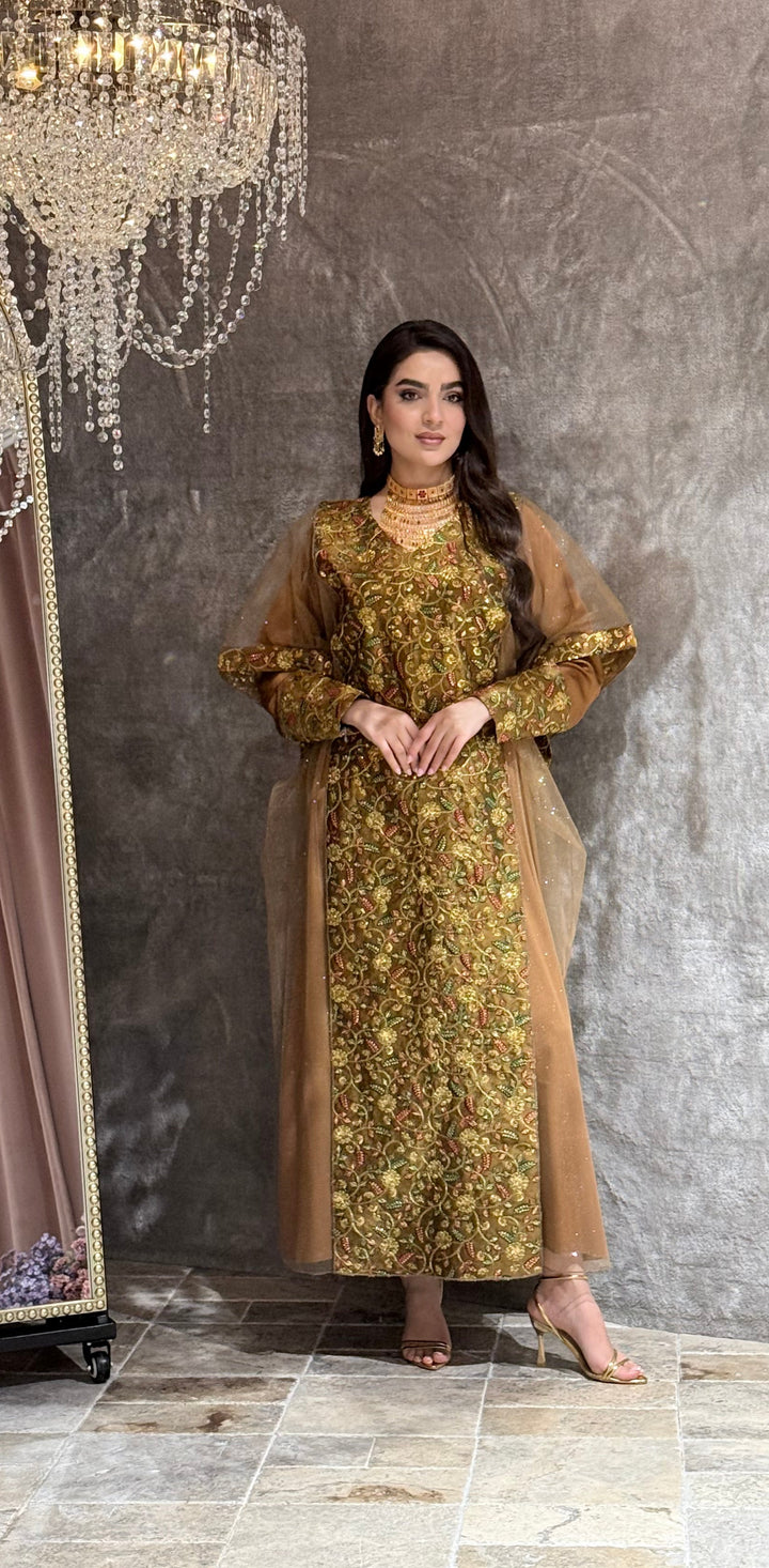 Woman in a Golden Brown Floral Embroidered Kaftan standing on a reflective floor with a chandelier in the background