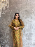 Woman in a Golden Brown Floral Embroidered Kaftan standing on a reflective floor with a chandelier in the background