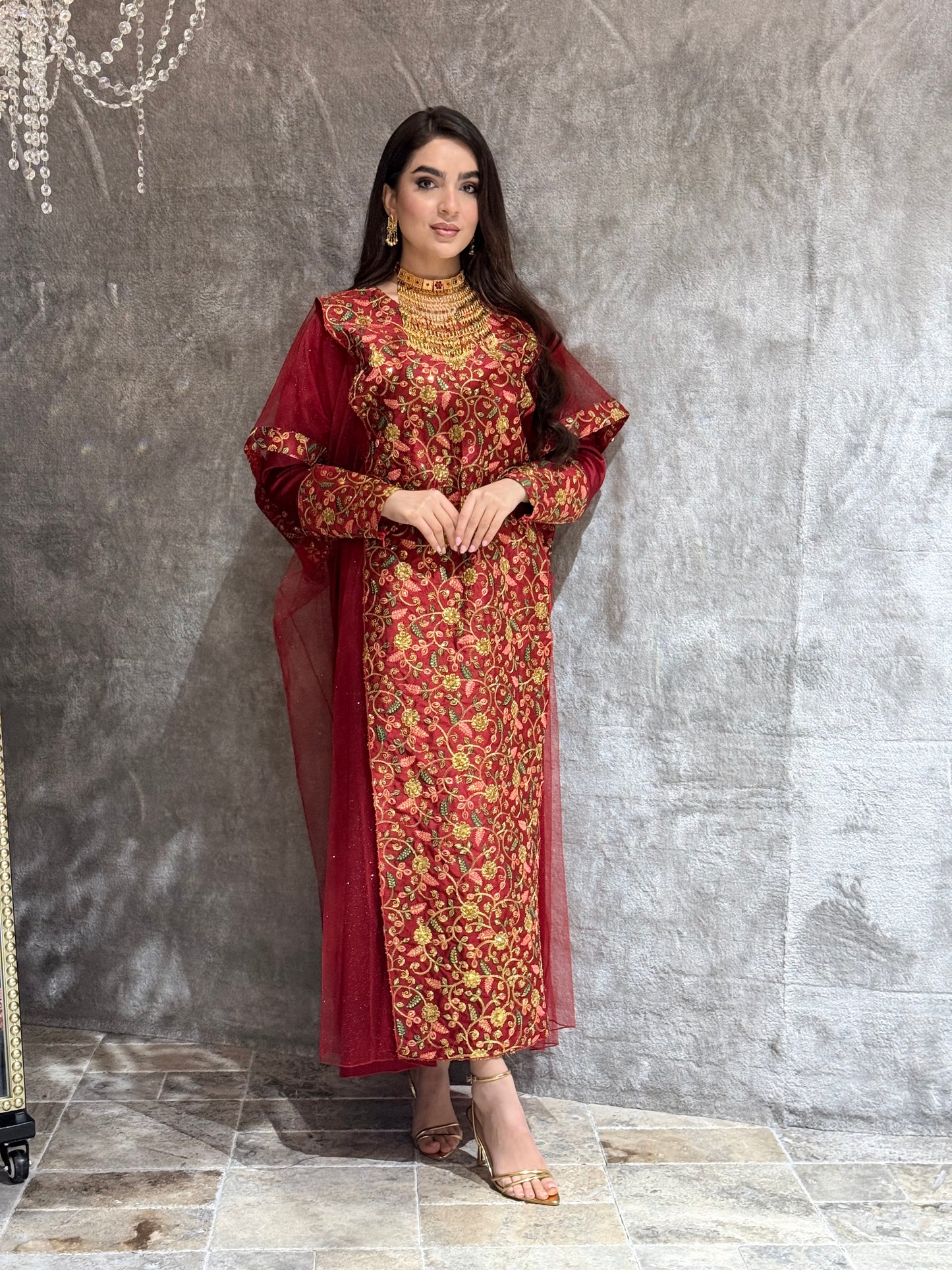 Woman in a Maroon Floral Embroidered Kaftan outfit lying on a tiled floor.
