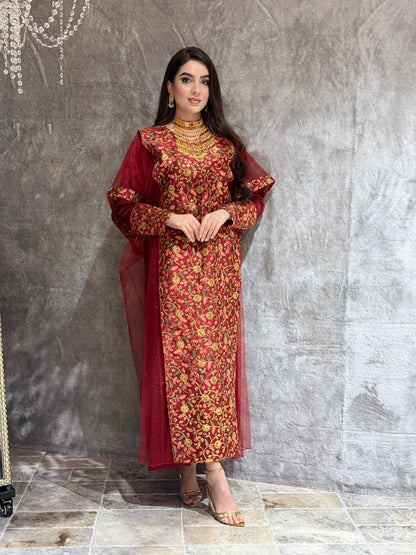 Woman in a Maroon Floral Embroidered Kaftan outfit lying on a tiled floor.