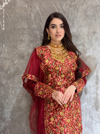 Woman in a Maroon Floral Embroidered Kaftan outfit lying on a tiled floor.