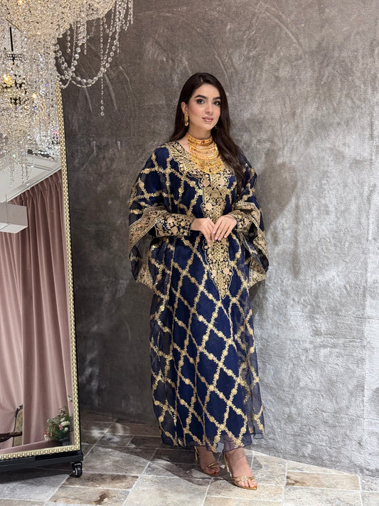 Woman in a Navy Blue Luxury Embroidered Kaftan traditional outfit lying on a textured surface.
