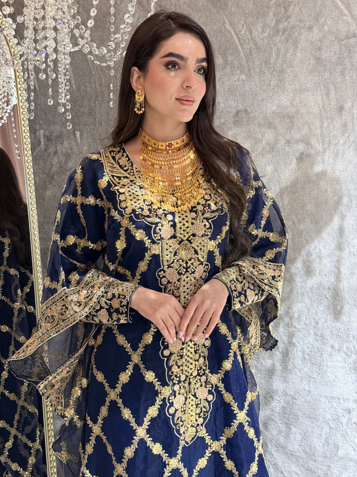 Woman in a Navy Blue Luxury Embroidered Kaftan traditional outfit lying on a textured surface.