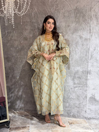 Woman in a Sage Green Luxury Embroidered Kaftan traditional outfit standing on a textured surface