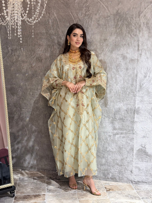 Woman in a Sage Green Luxury Embroidered Kaftan traditional outfit standing on a textured surface