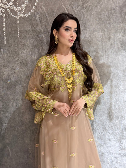Woman in a Beige Luxury Embroidered Kaftan traditional outfit with gold embroidery lying on a textured surface