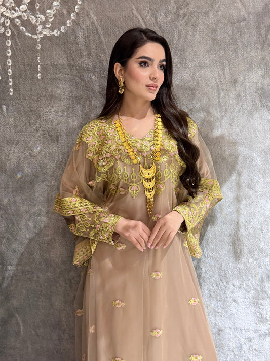 Woman in a Beige Luxury Embroidered Kaftan traditional outfit with gold embroidery lying on a textured surface