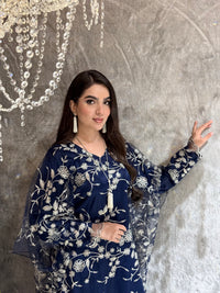 Woman in a Navy Blue Floral Embroidered Kaftan lying on a textured surface