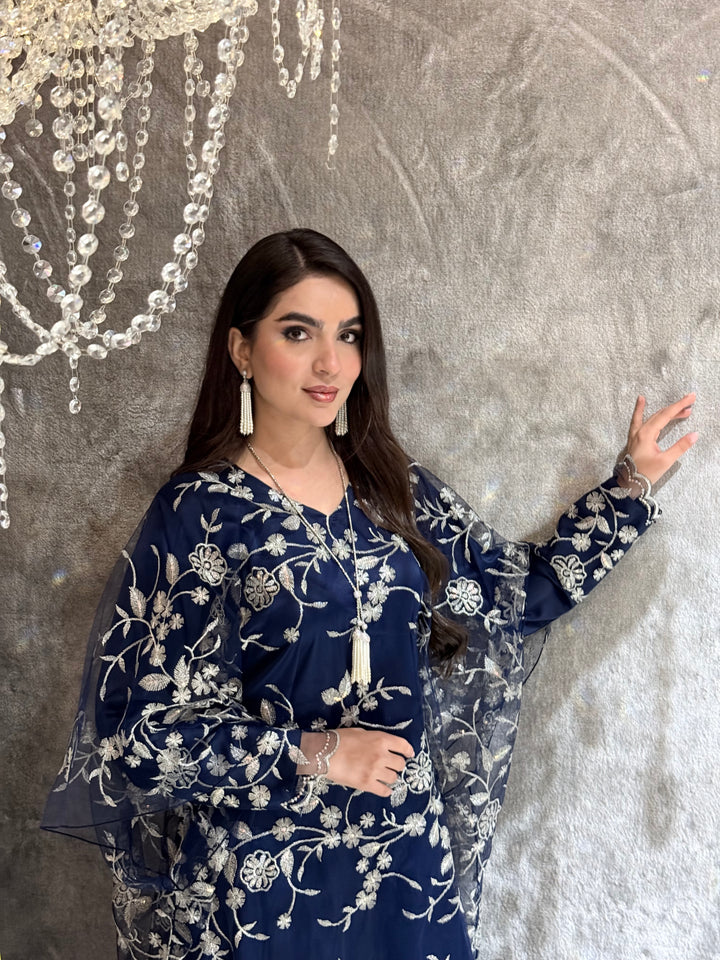 Woman in a Navy Blue Floral Embroidered Kaftan lying on a textured surface
