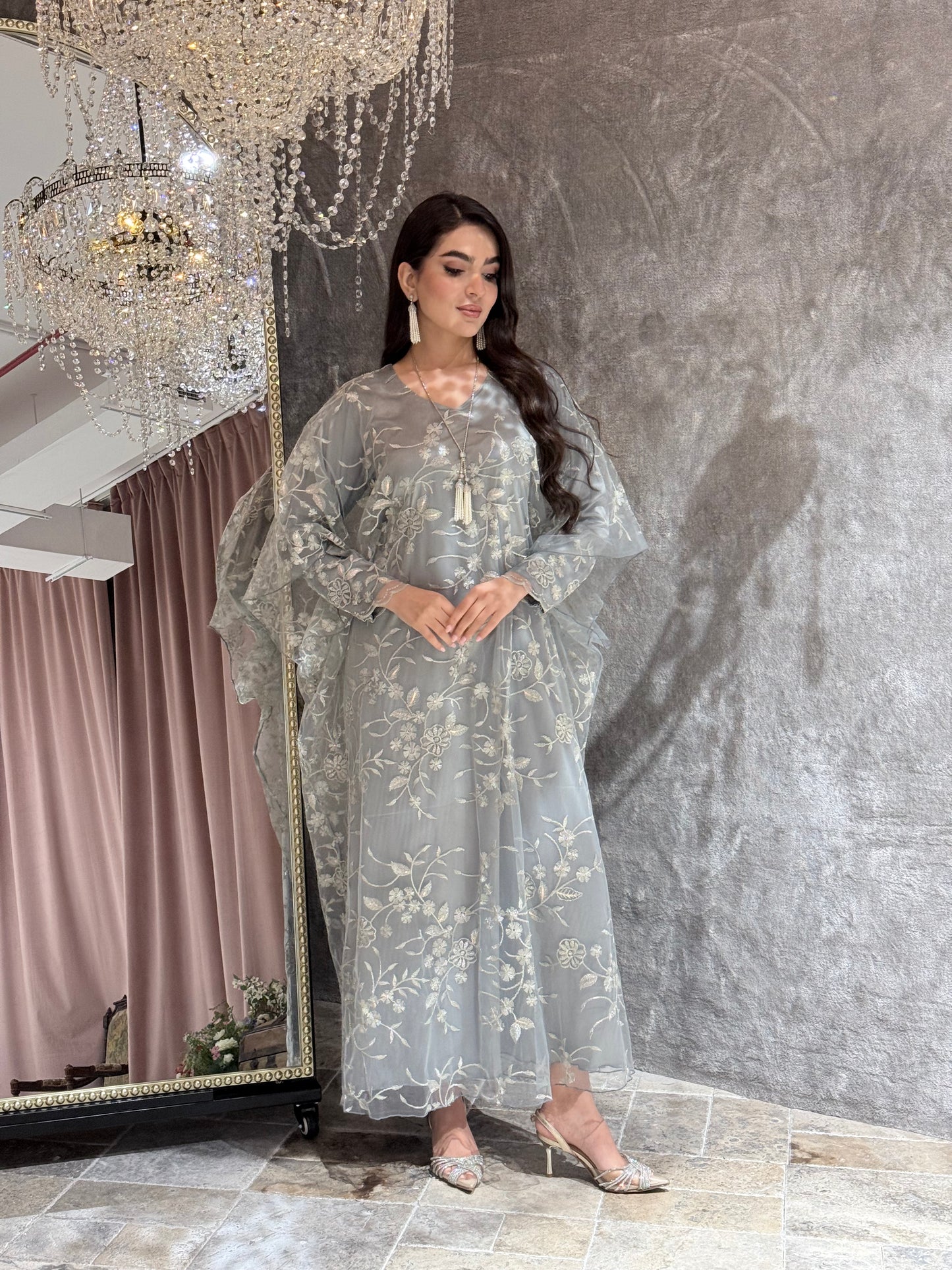 Woman in a Silver Grey Floral Embroidered Kaftan lying on a textured gray surface