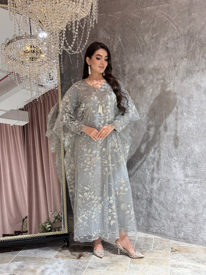 Woman in a Silver Grey Floral Embroidered Kaftan lying on a textured gray surface