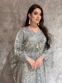 Woman in a Silver Grey Floral Embroidered Kaftan lying on a textured gray surface
