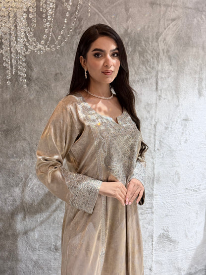 Woman in a beige kaftan jalabiya dress standing on a textured surface