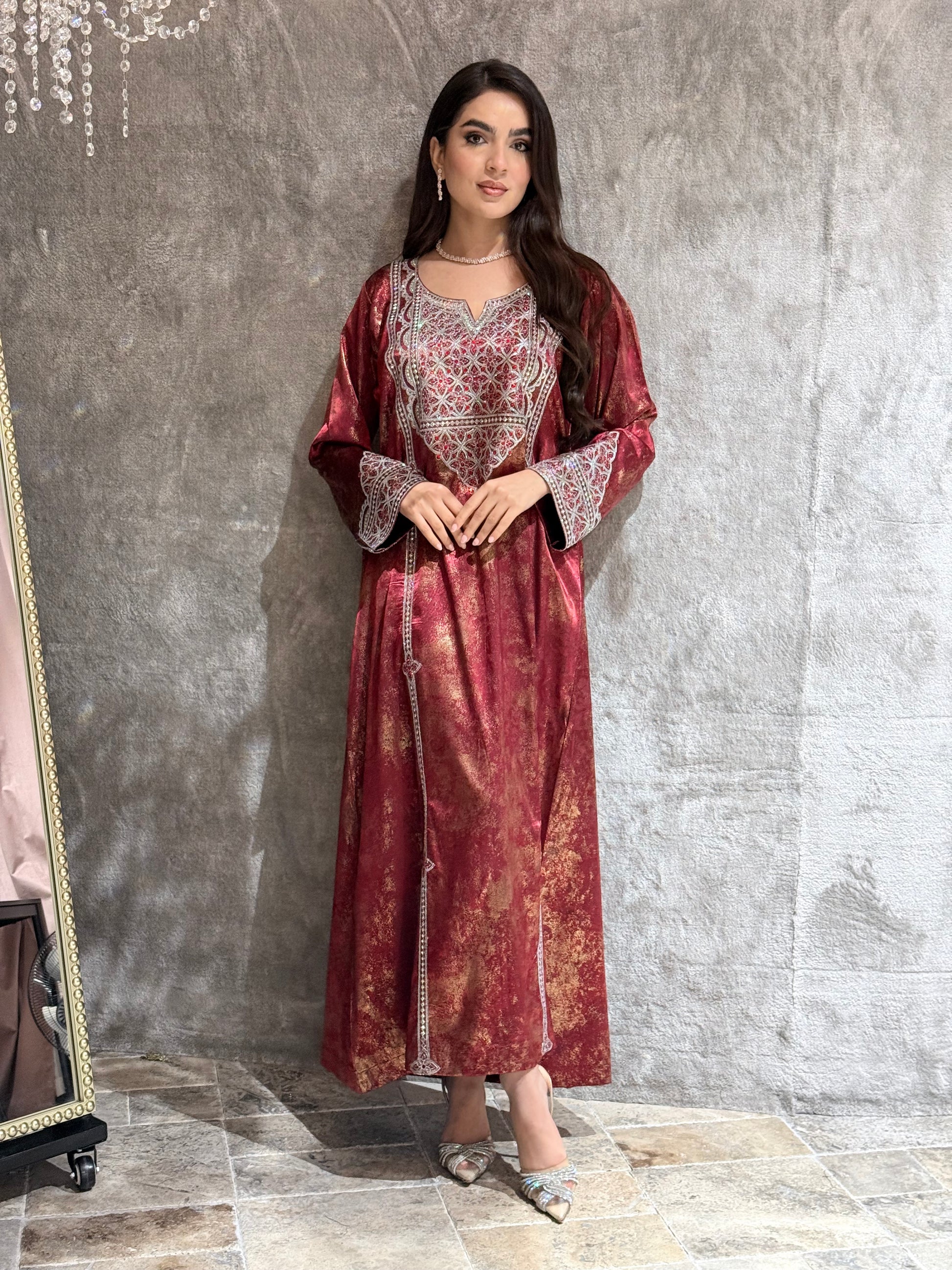 Woman in a Burgundy Metallic Luxury Kaftan dress standing on a marble floor