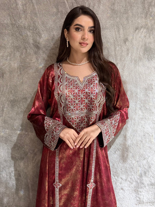 Woman wearing a Burgundy Metallic Luxury Kaftan outfit on a textured gray background