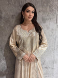 Woman in a Cream Metallic Luxury Kaftan dress standing on a gray textured surface