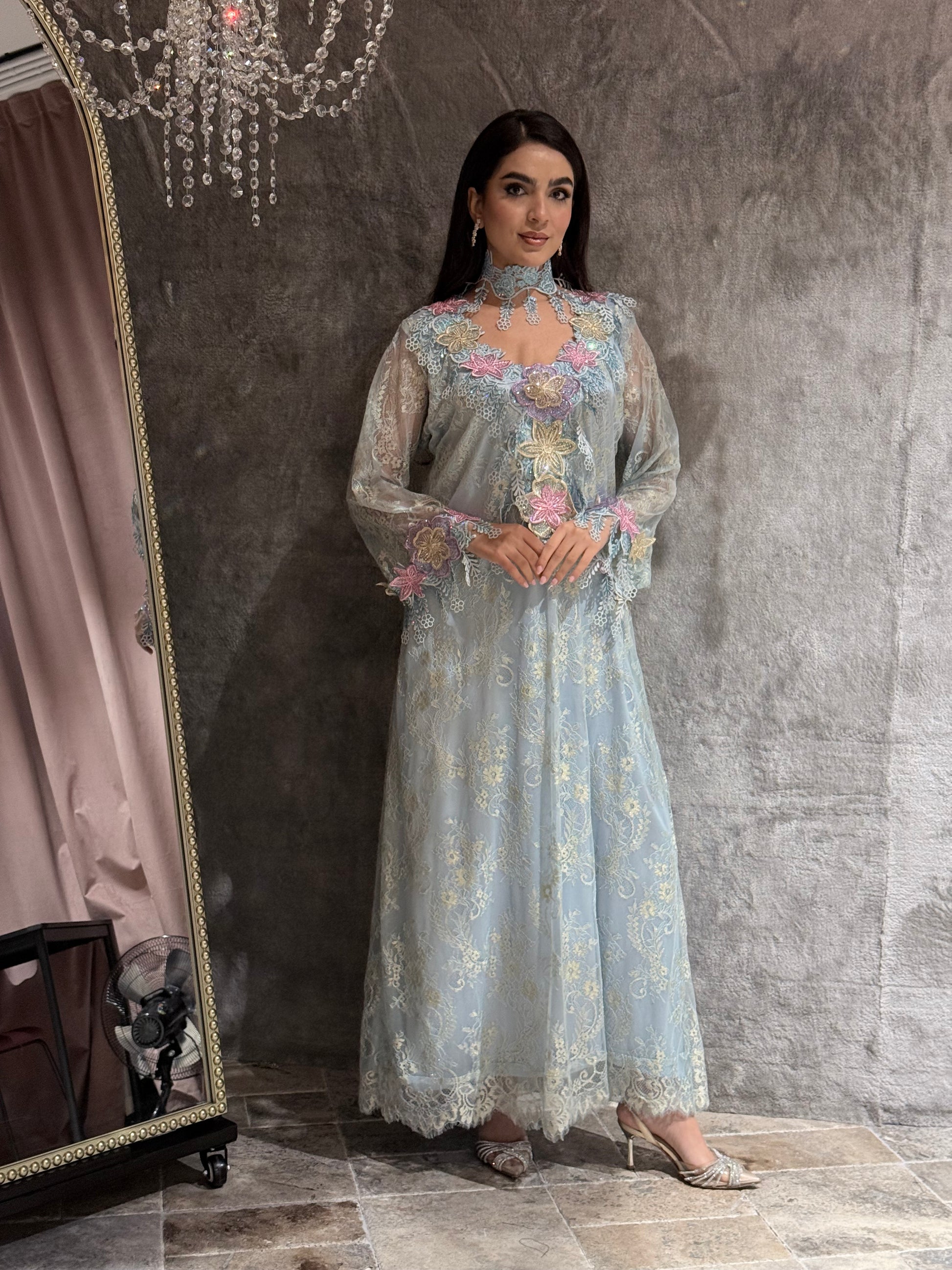 Woman in a Baby Blue Floral Lace Luxury Kaftan embroidered dress standing in front of a mirror.