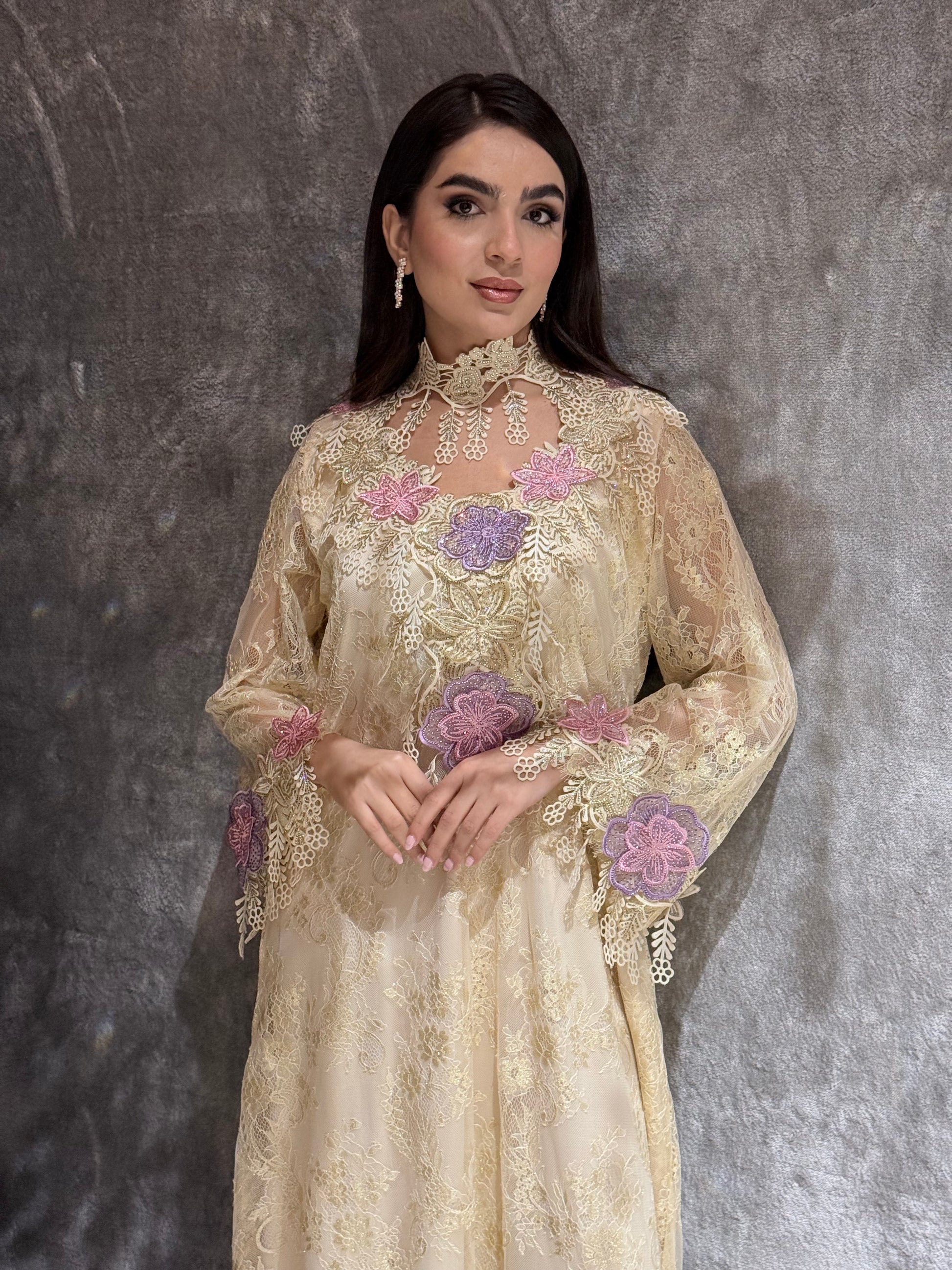 Woman wearing a Cream Floral Lace Luxury Kaftan embroidered dress with floral patterns on a gray background