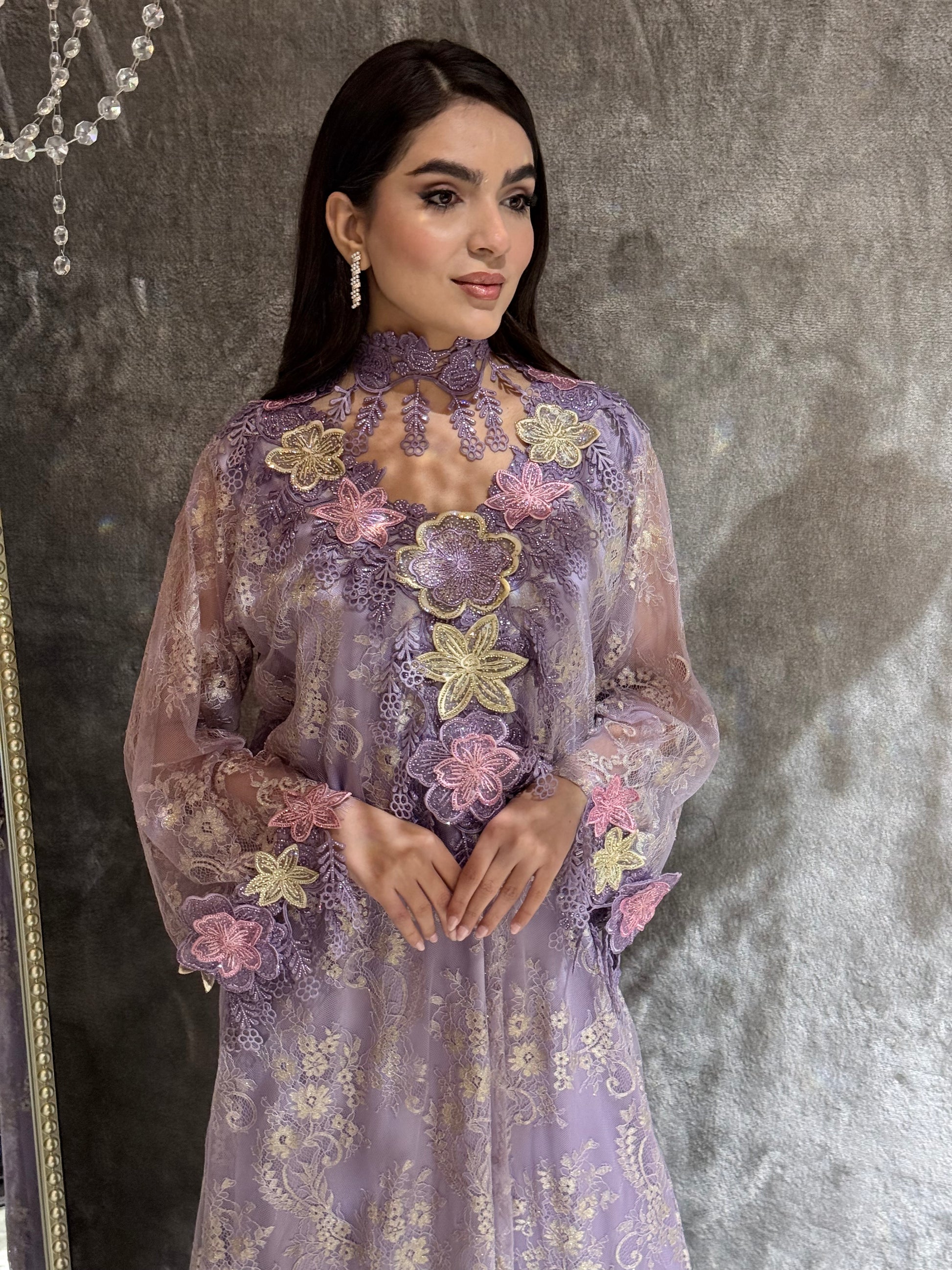 Woman in a Lavender Mist Floral Lace Luxury Kaftan floral dress standing on a textured floor.