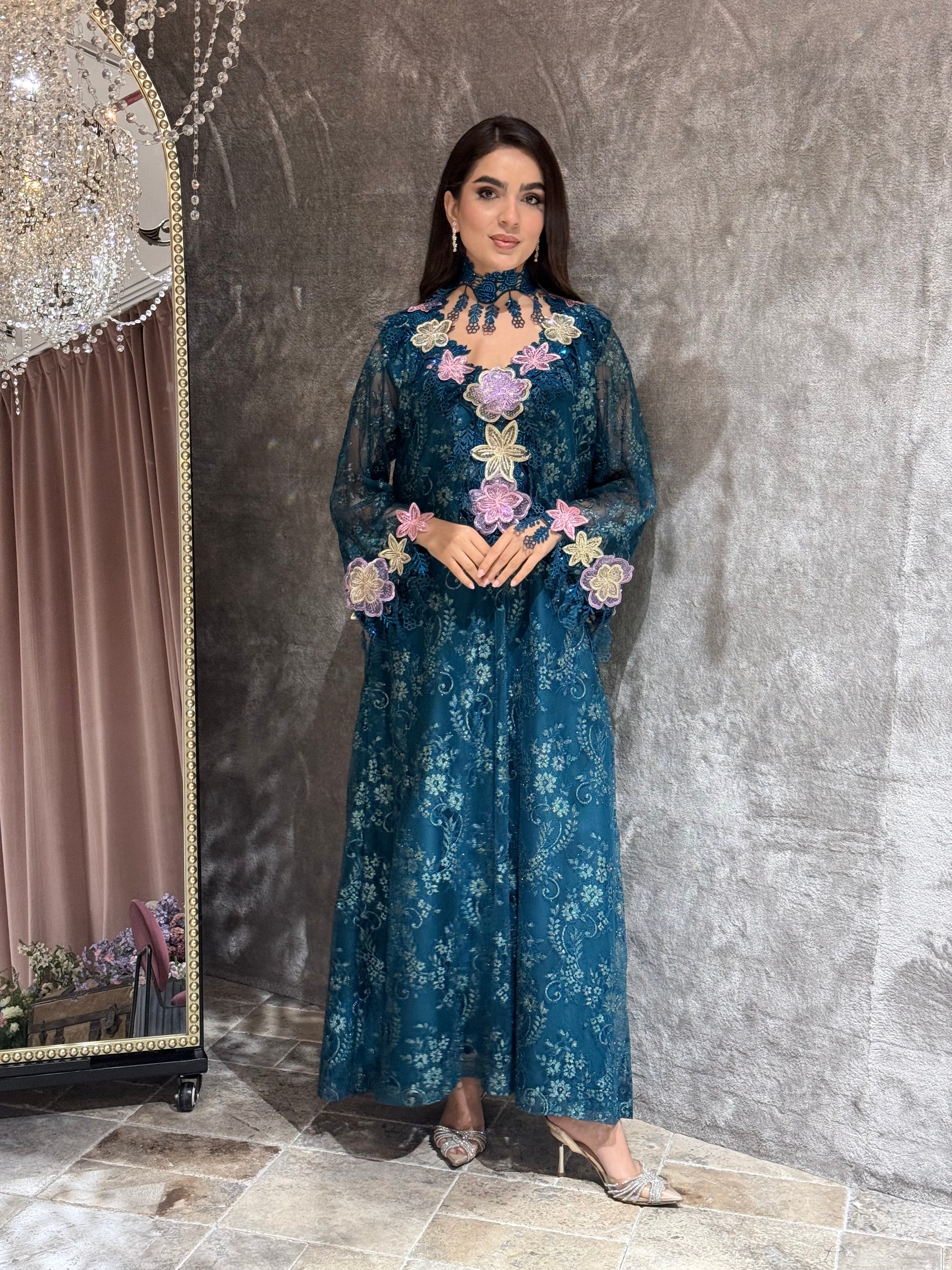 Woman in a Majestic Teal Floral Lace Luxury Kaftan dress standing in front of a mirror.